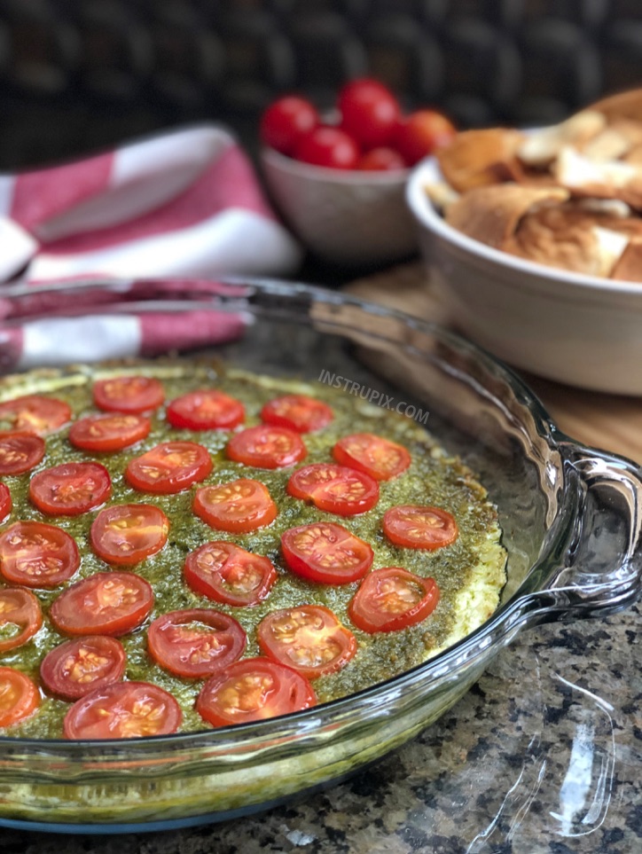 OMG, the best!! 3 Ingredient Warm Caprese Dip Recipe - This easy appetizer dip for a party is a real crowd pleaser! Made with cream cheese, basil pesto and tomatoes. It's perfect served with pita chips, bread or crackers. | #instrupix #appetizers #diprecipes #partyfood #caprese #basilpesto #creamcheese