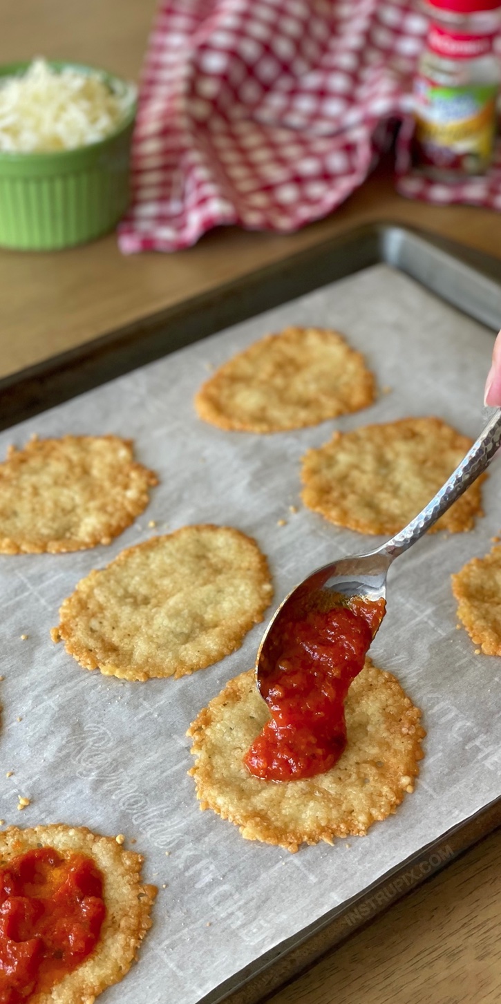 Mini Parmesan Crust Pizzas | A super quick and easy low carb recipe! Making a pizza crust doesn't get any easier than this. Just grated parmesan baked in the oven! Top with sauce, mozzarella, and pepperoni for the best keto snack, ever. Great served with a salad for dinner or lunch, too! Naturally gluten free with no flour.