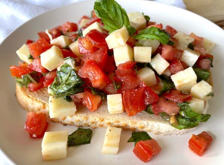 Caprese Toast | A super yummy, quick, and easy vegetarian lunch and quick dinner! This delicious recipe is made with just a few simple and fresh ingredients including mozzarella cheese, tomatoes, fresh basil and olive oil. Serve with toasted sourdough or French bread, or a sliced baguette!
