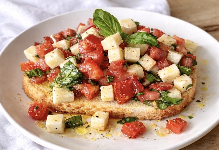 Basil, tomato, and cheese recipe over toast made with extra virgin olive oil and garlic.