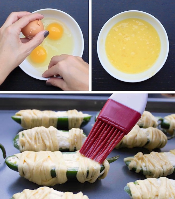 Brushing egg wash onto cream cheese stuffed Jalapeno peppers wrapped in thin strips of dough to make a fun and easy Halloween appetizer for parties. 