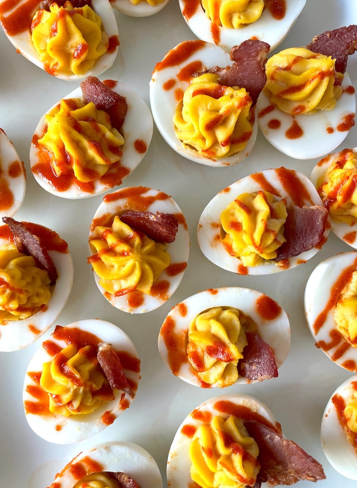 Delicious deviled eggs made with Chick-fil-A sauce, sriracha and crispy bacon to make a crowd pleasing appetizer for parties. 