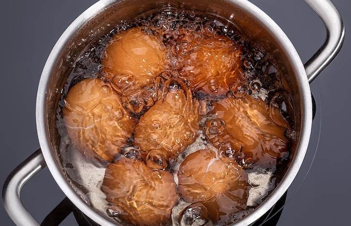 Brown eggs boiling in a pot of water to make Deviled Eggs. 