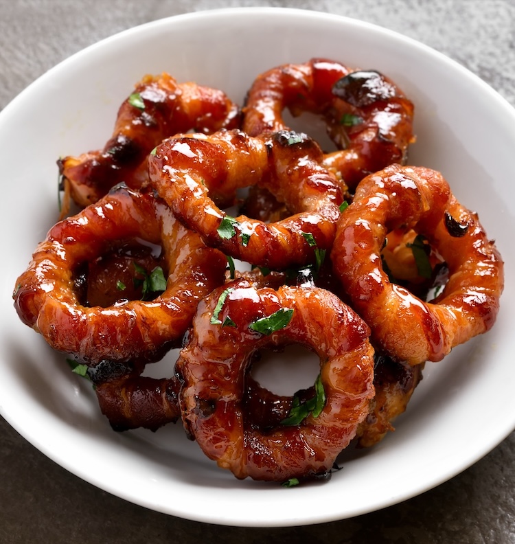 Crispy bacon wrapped onion rings in a bowl ready to be devoured. 