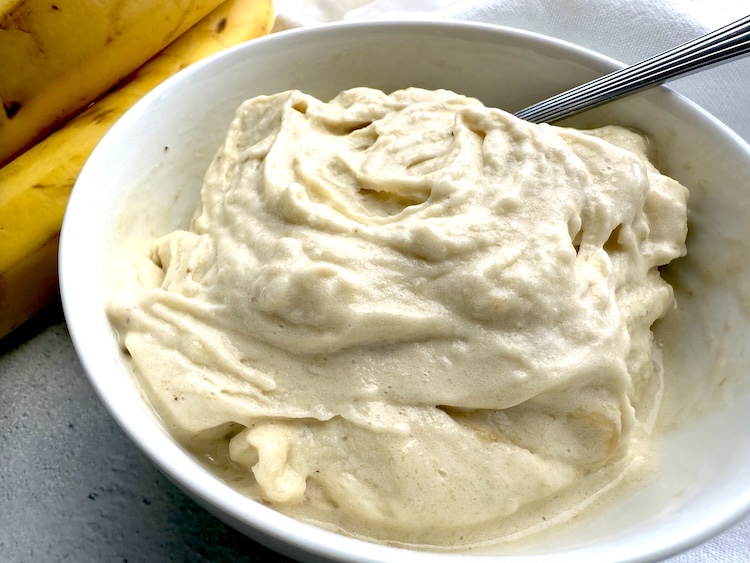 Banana frosty in a bowl made in a blender with frozen bananas and other optional mix-ins. 