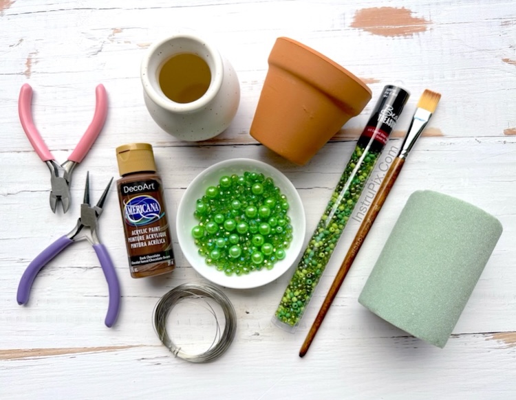 Picture of supplies needed to make beaded plants: small clay pot, floral foam, brown paint, small paint brush, variety of green beads, 26 gauge wire, wire cutters, and round nose pliers. 